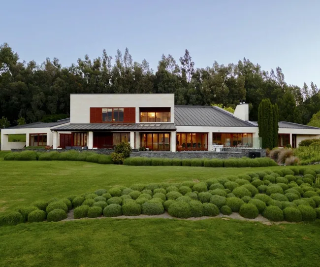 A white, double-storey home in a field