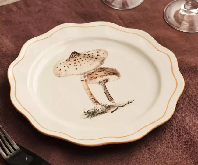 A white dinner plate with mushroom design