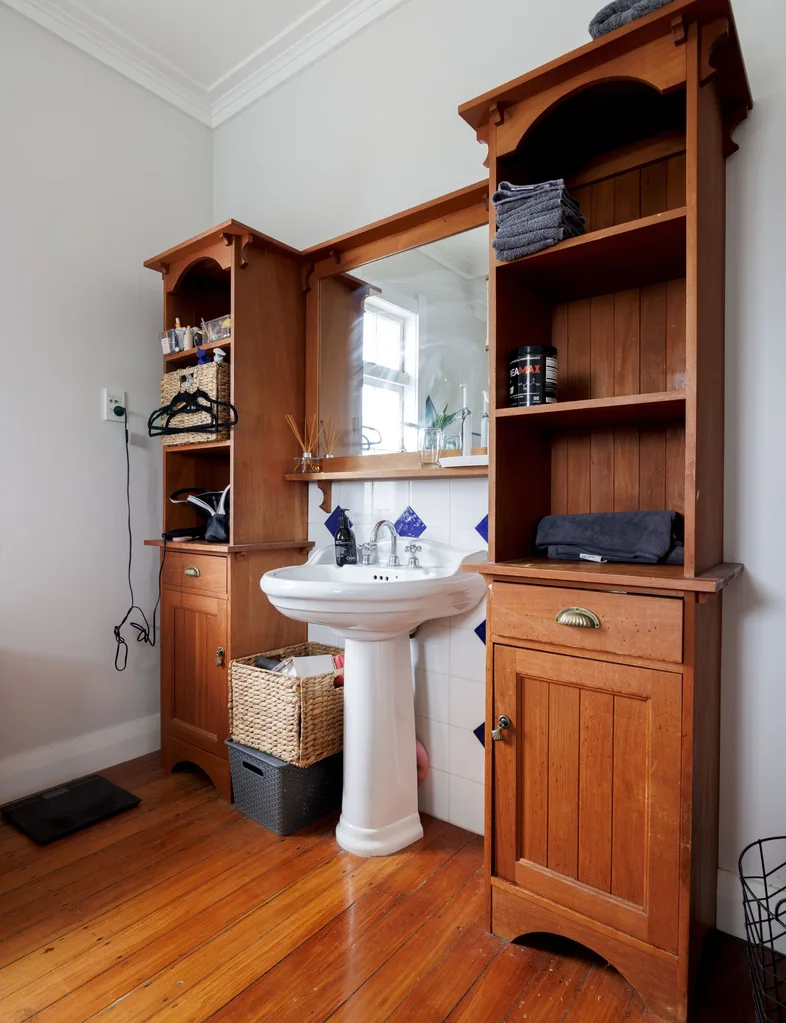 The old bathroom in Liam Messam's home features a single sink and wooden cabinetry
