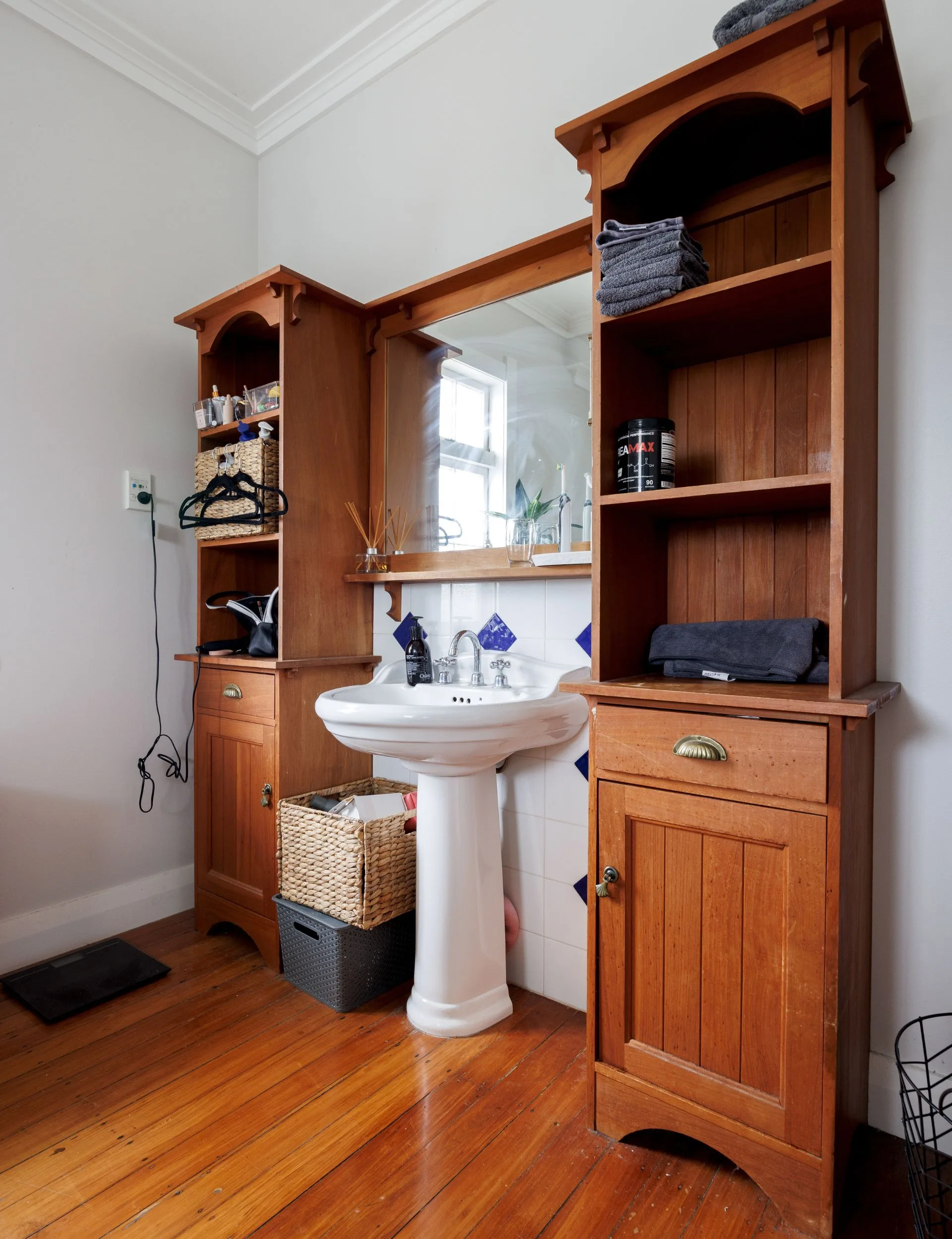 The old bathroom in Liam Messam's home features a single sink and wooden cabinetry
