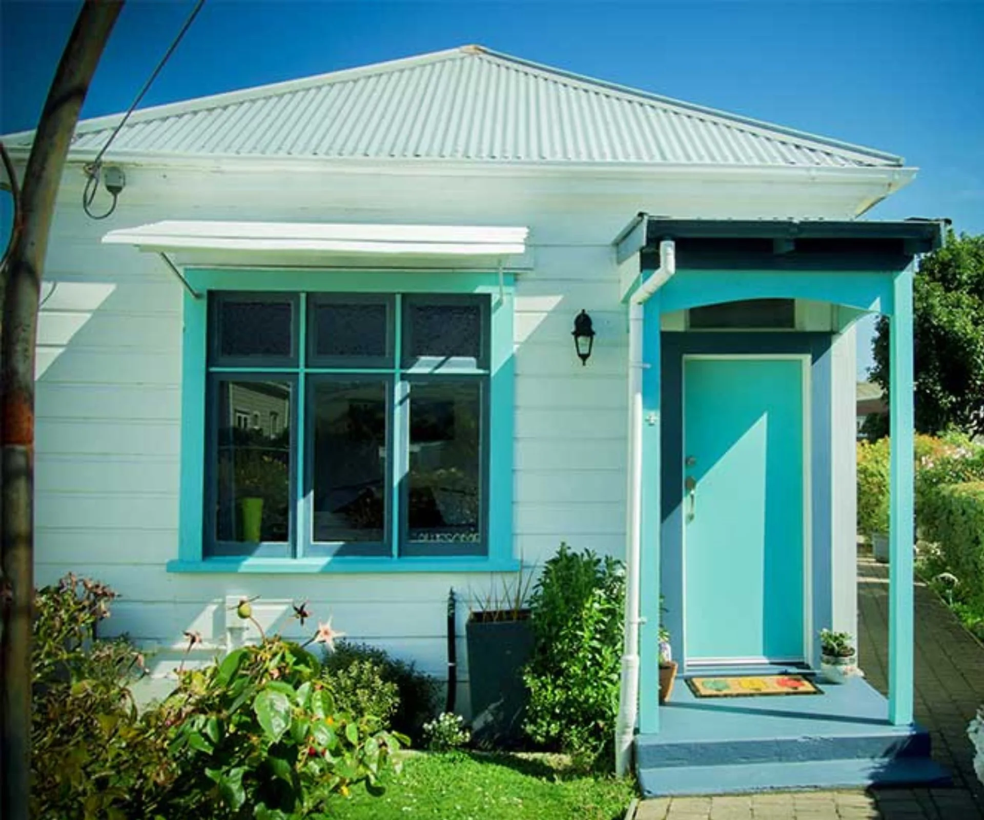 Bold blue accent colours stand out against the white weatherboards of this home