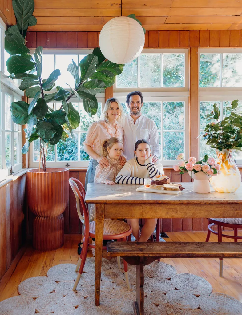 Gretchen Lowe with her family in kitchen with cake and flowers