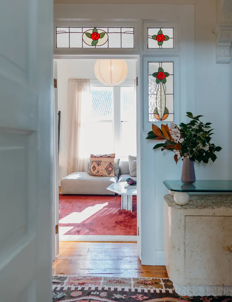 hallway entry to lounge with grey couch