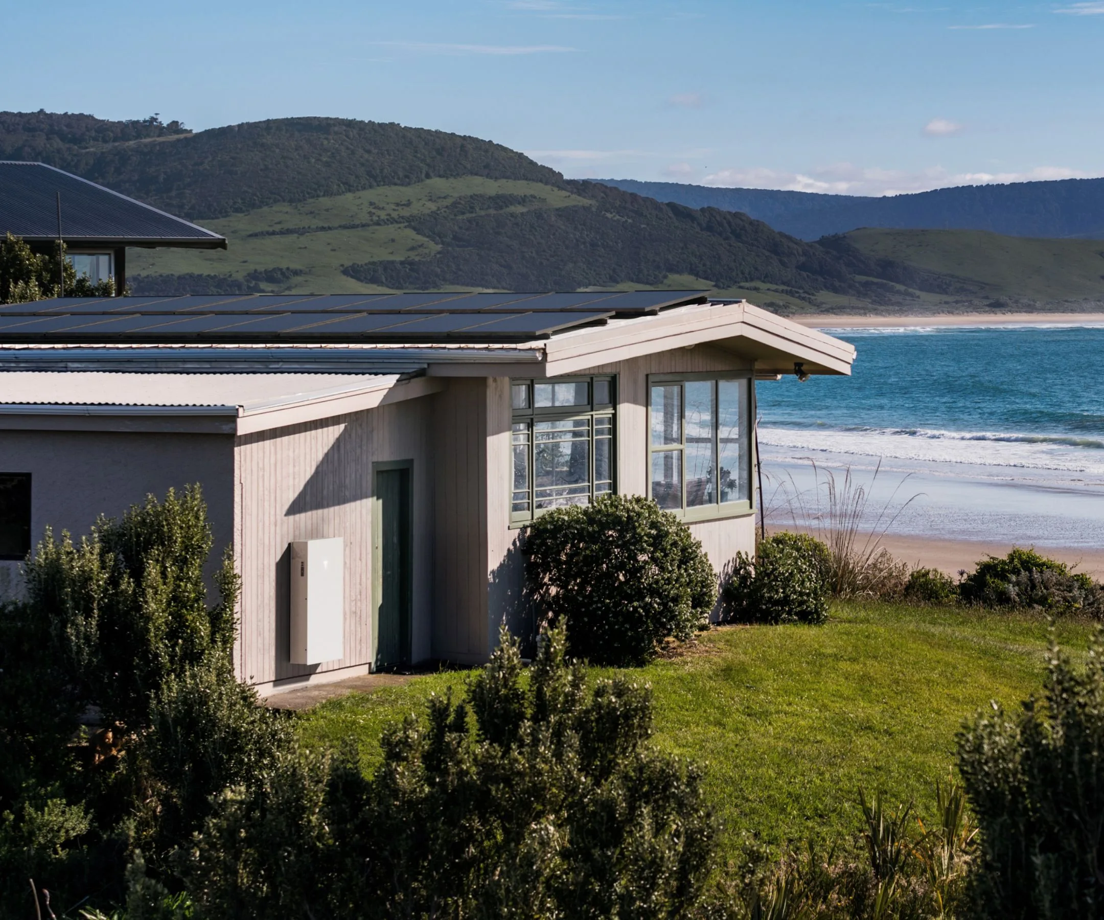 The Powerwall 3 against a beach house 