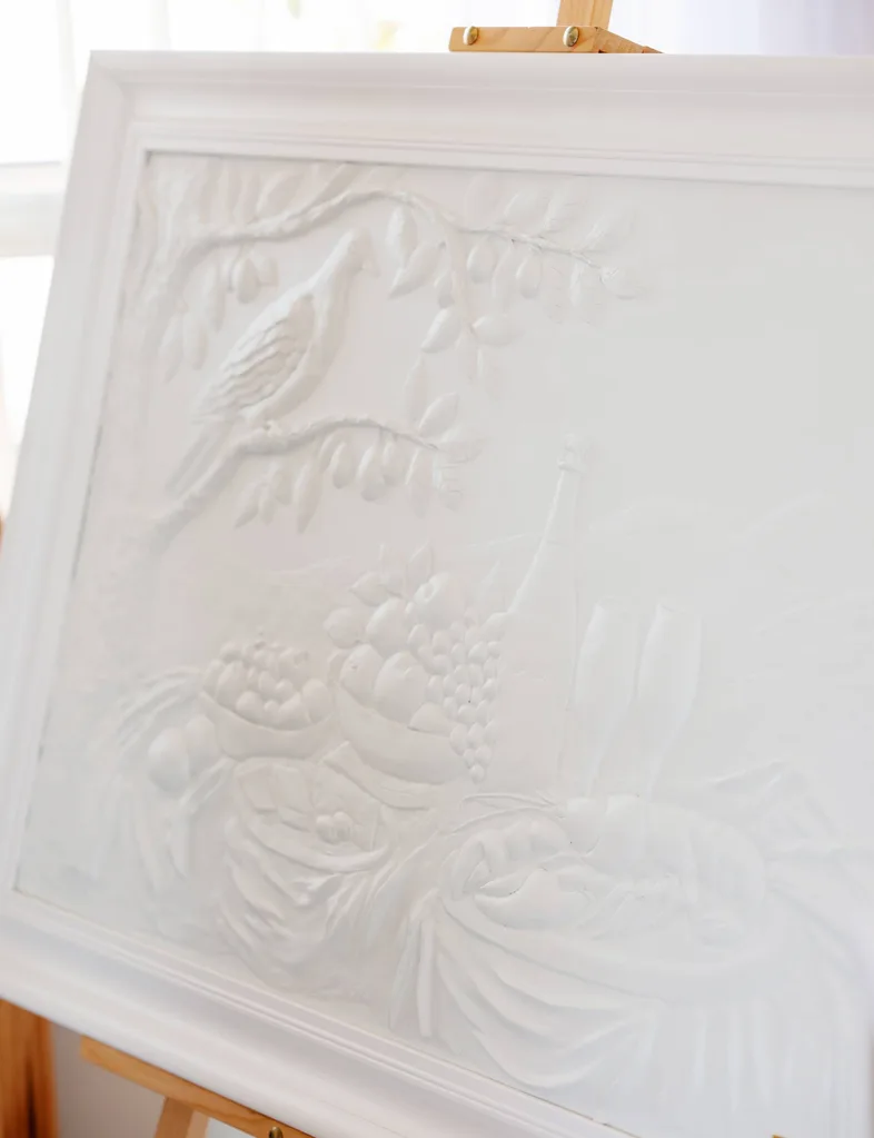 A white relief still life artwork.