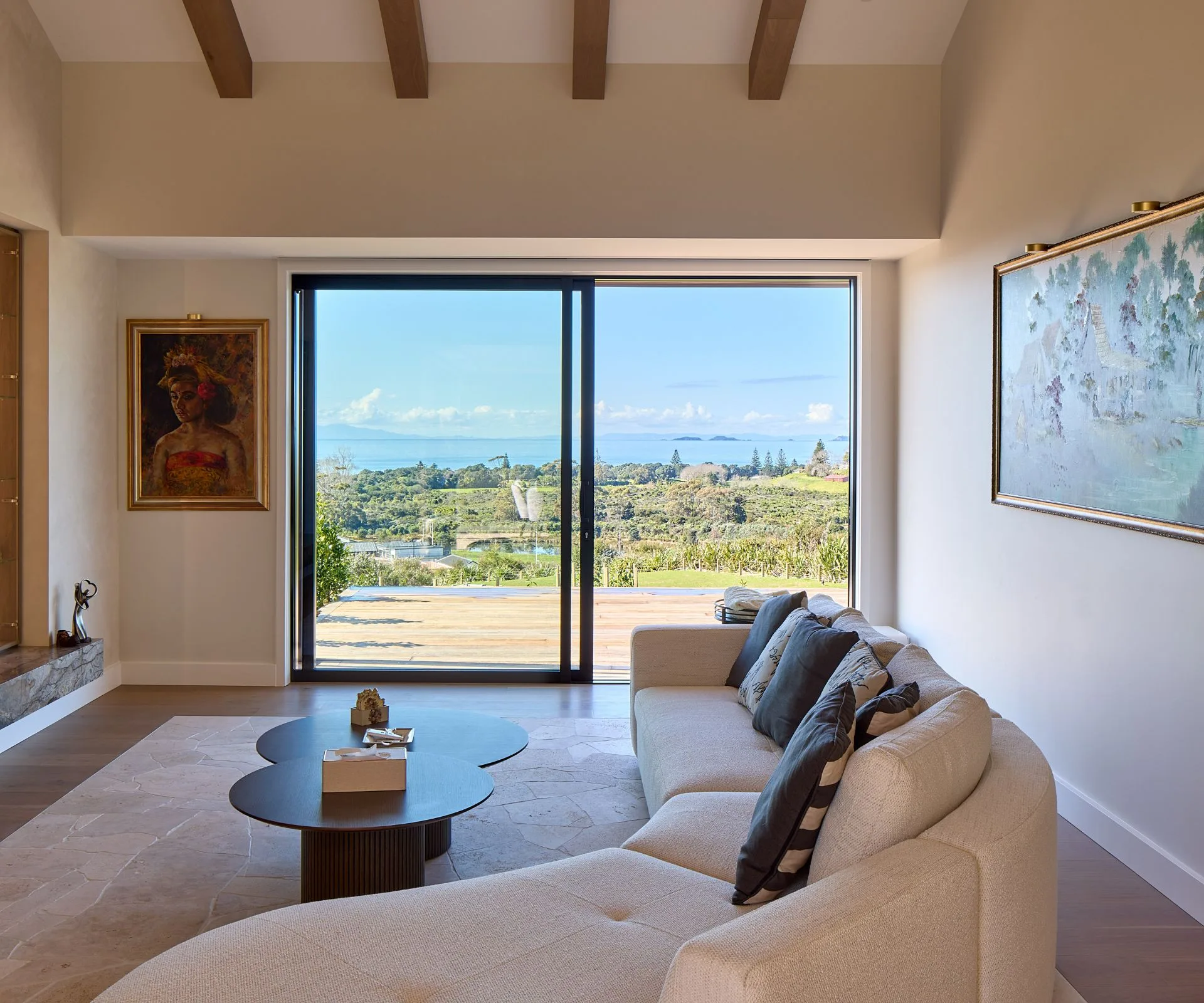 The living space in this Long Bay home opens to sweeping views of Hauraki Gulf through Vantage sliding doors