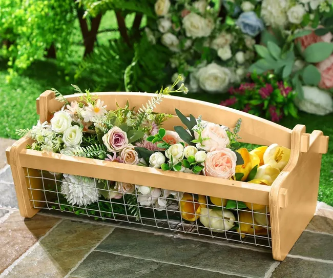 A wooden and metal trug full of flowers
