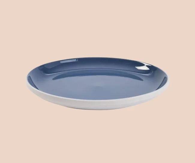 A blue dinner plate against a pink background