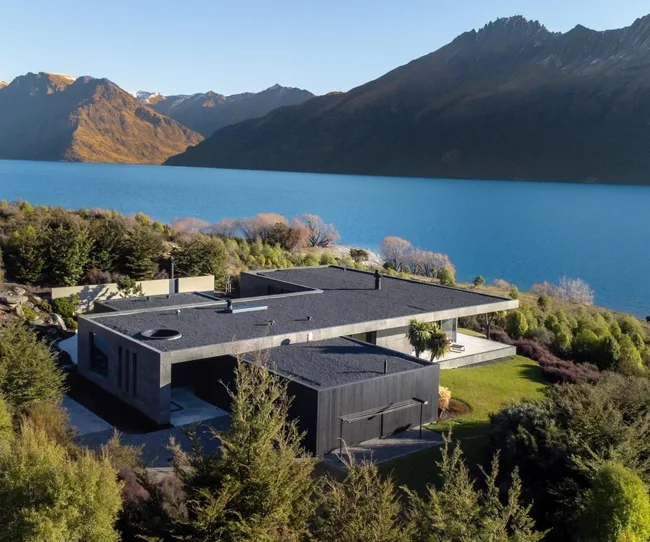 A concrete, modern home on the edge of a lake