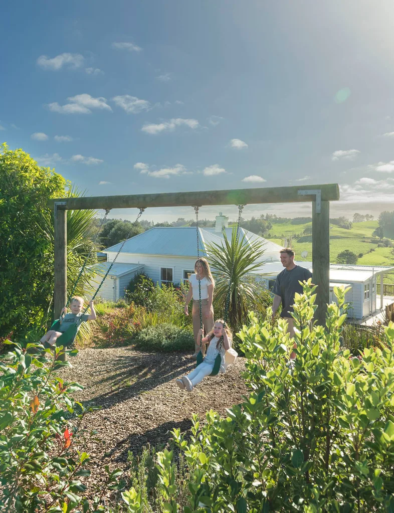A family playing on a swing set.