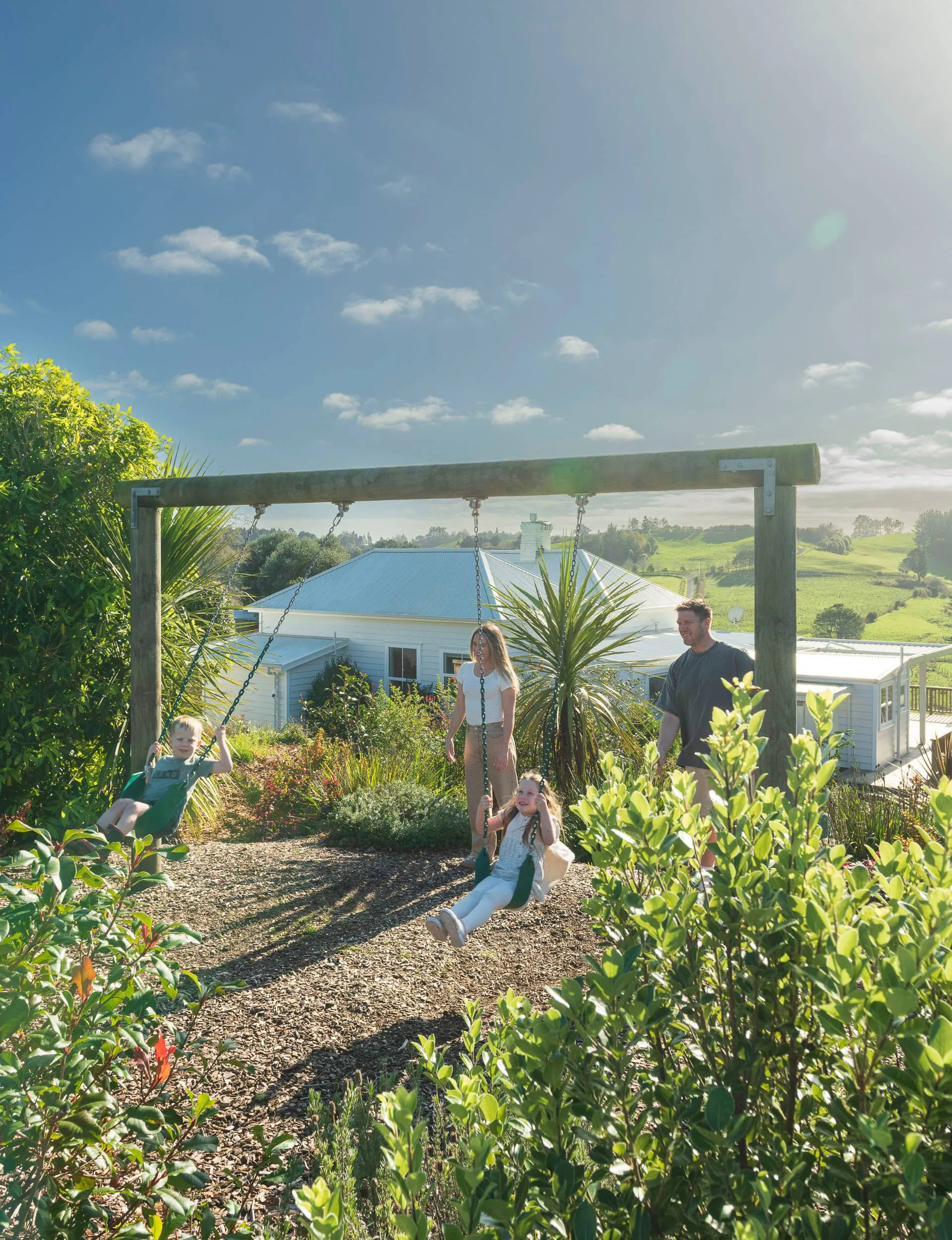 A family playing on a swing set. 