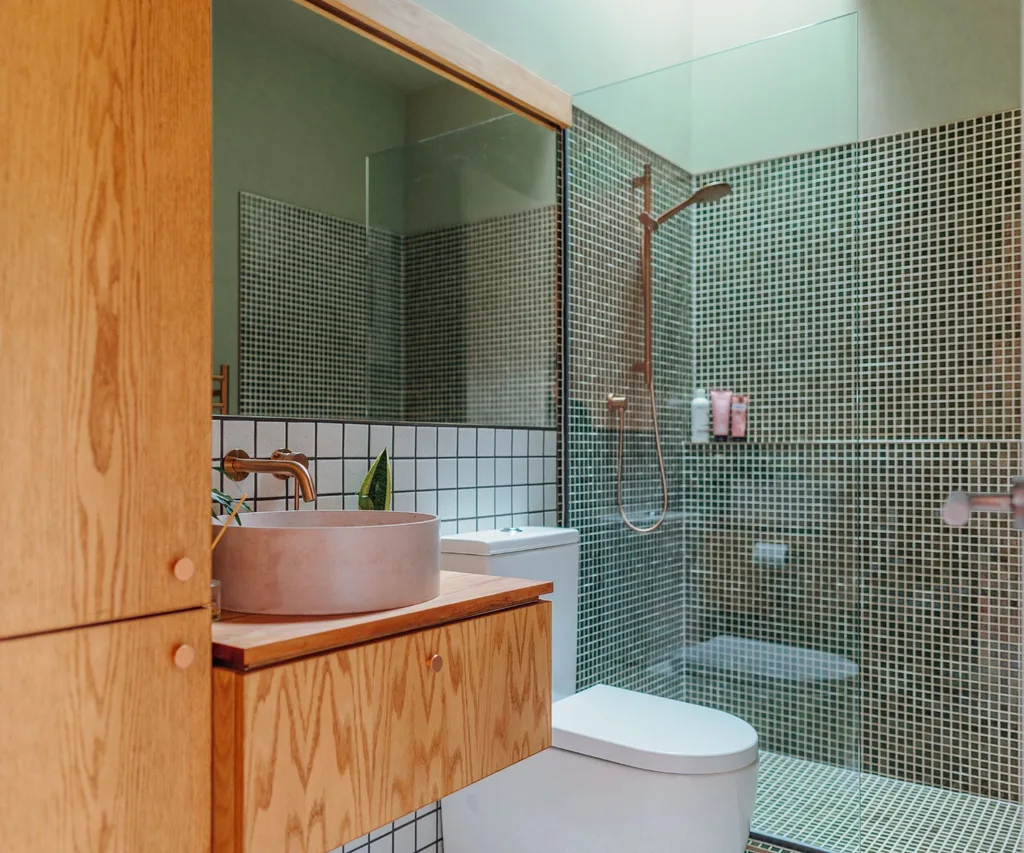 The bathroom is painted in an olive green, a stark contrast to the soft pinks and reds of the rest of the house