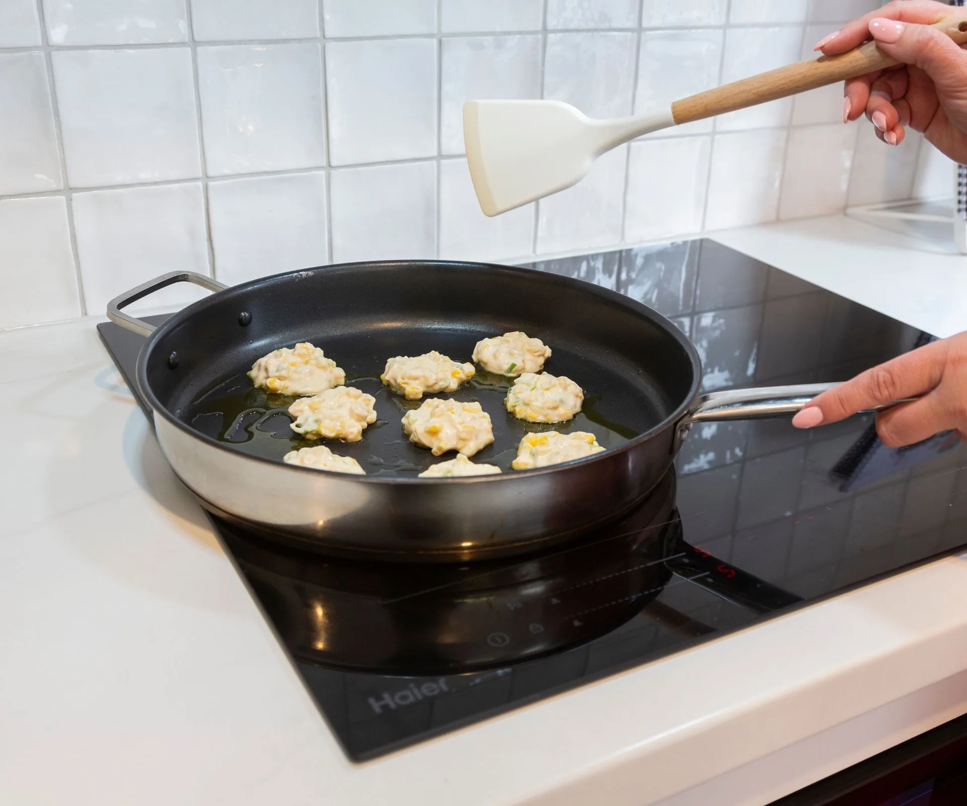 Jana cooking corn fritters on her Haier cooktop 