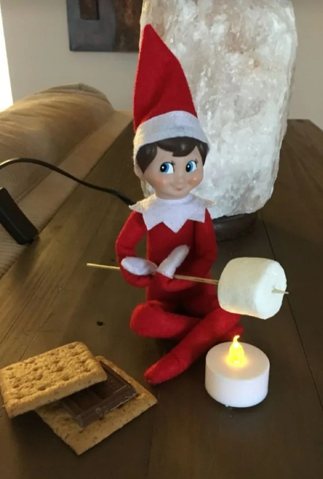 Elf toasting a marshmallow on an electric candle