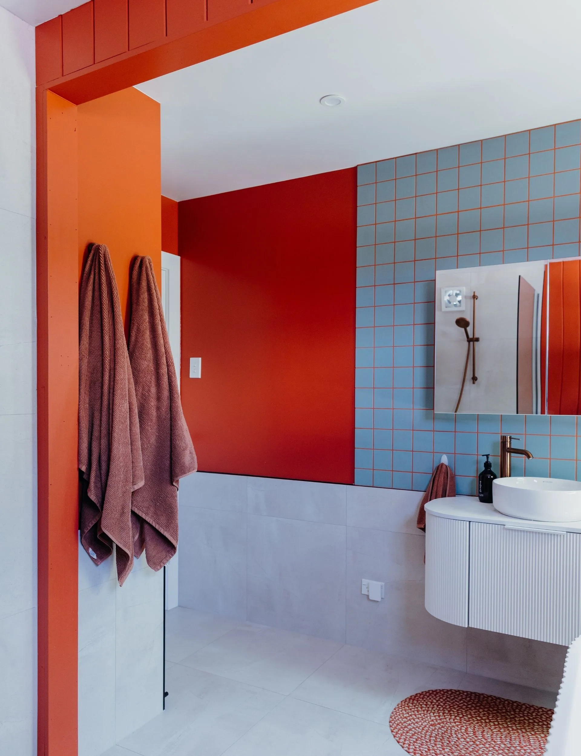 The terracotta coloured walls pair perfectly with the turquoise tiles