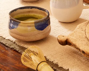 cups of matcha and whisk on a table