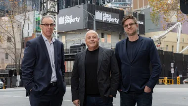 Chris Lucas in centre of two men outside Melbourne property development at 435 Bourke Street