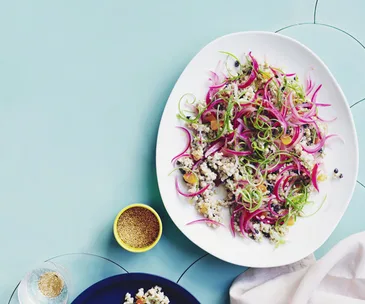 Grain salad with tahini, grilled spring onion and baharat dressing