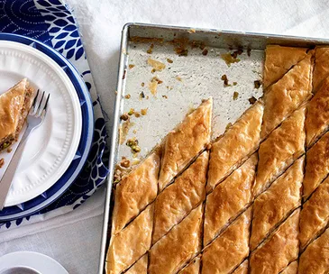 A metal tray of baklava, sliced into diamond shapes.