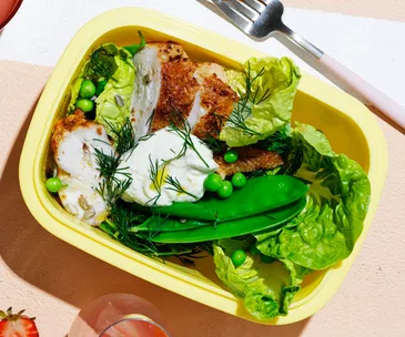 Roast chicken salad with peas and almond-lemon dressing in a yellow lunchbox