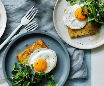 Hash browns with eggs fried in olive oil and herb salad recipe
