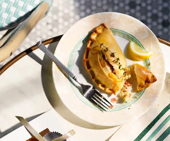 Golden half moon folded pastry on a plate.