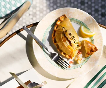 Golden half moon folded pastry on a plate.