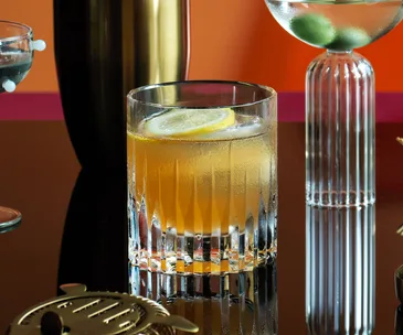 Auterra#2 cocktail in a glass with a slice of lemon.