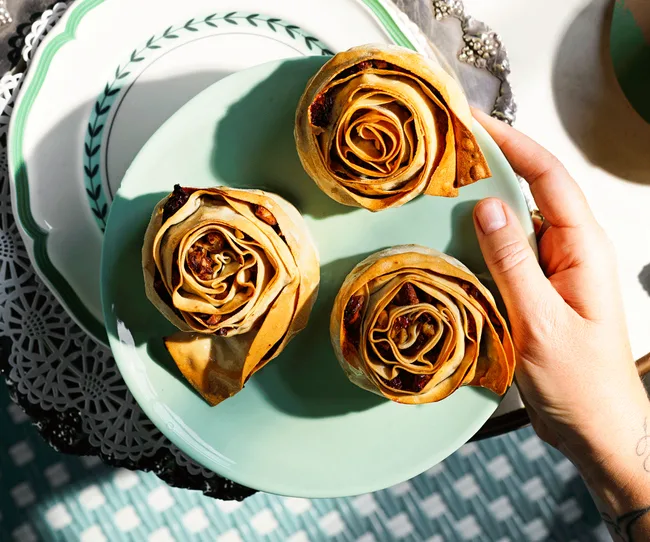 Aerial view of three Calabrian dried fruit and nut pastries on a blue plate.