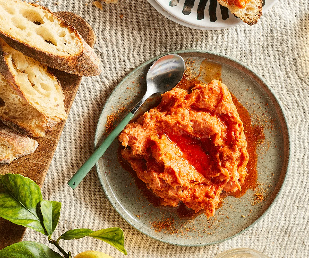 Grey ceramic plate of Pappalá with a spoon. Crusty bread to the side of the image.