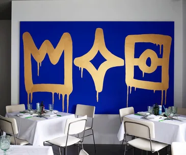 Di Stasio Carlton, Melbourne restaurant dining room with blue and gold artwork and crisp white furniture