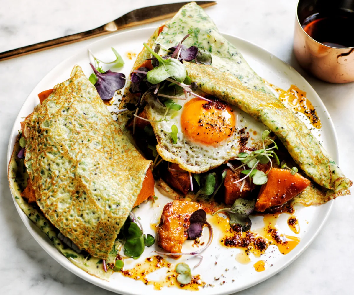 Plate of mixed seed and spice crêpes with roasted pumpkin