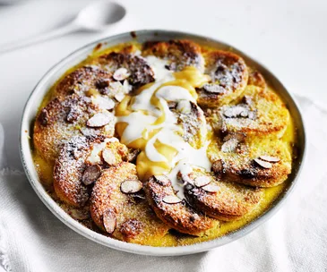 Lemon curd and almond bread and butter pudding in bowl.