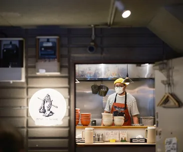 Tokyo ramen shop interior with ramen chef in the kitchen and restaurant sign
