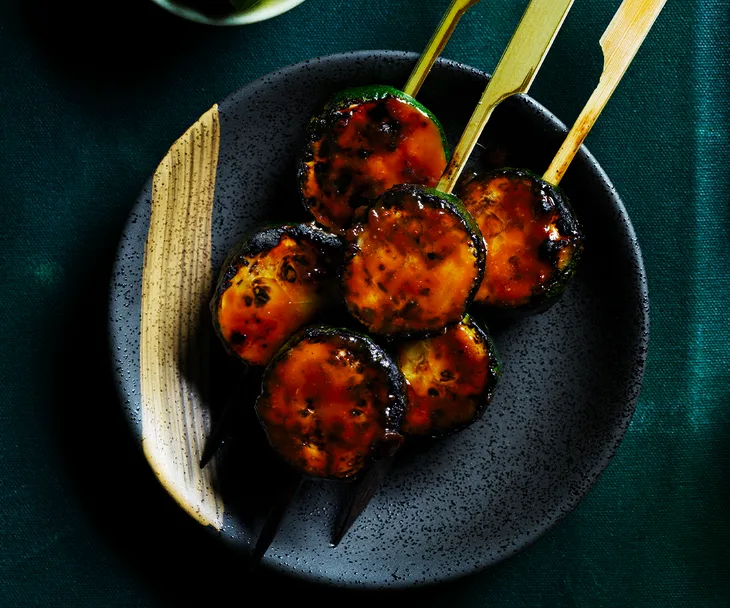 Japanese Zucchini skewers on dark coloured plate