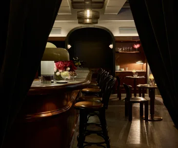 Dimly lit bar and timber chairs at soon-to-open Apollo Inn in Melbourne