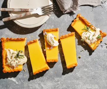 An aerial view of several rectangular slices of lemon and rosemary tart.