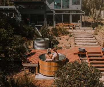 Two people in Wildacre's outdoor cedar hot tub in Blackheath.