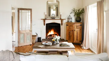Neutral and timber cottage living room with an open fire.