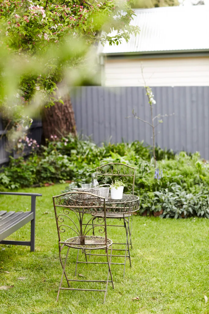 Wire outdoor furniture setting in the garden of a restored cottage in regional Victoria.