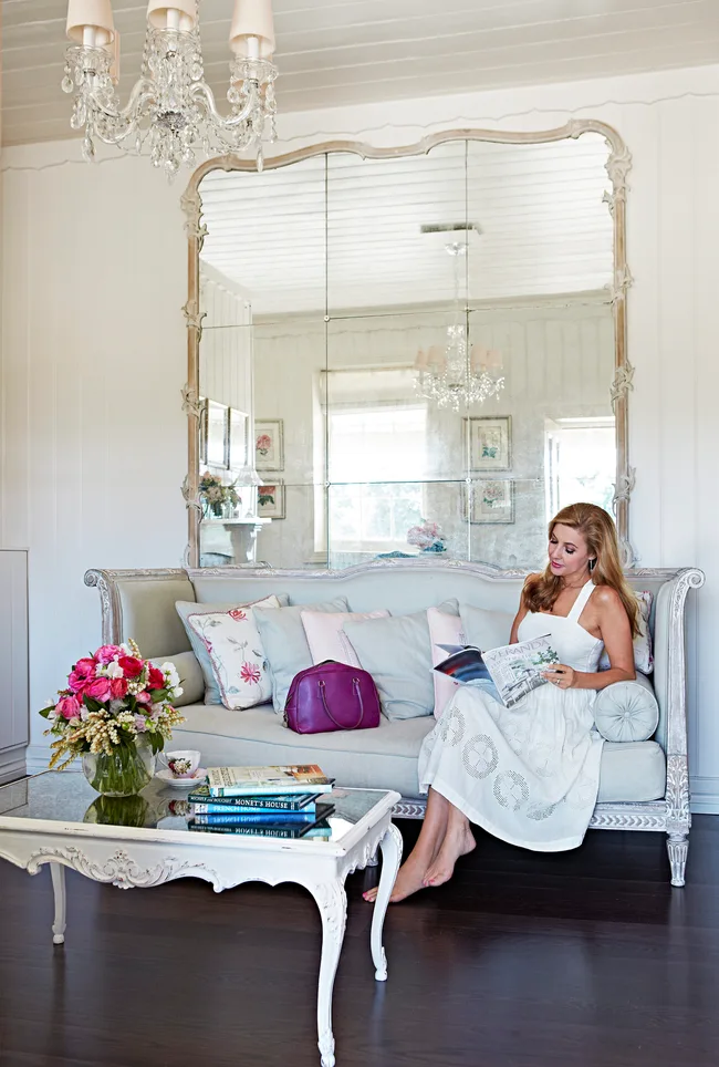 Catriona Rowntree reads on a French provincial style lounge in her guest house.