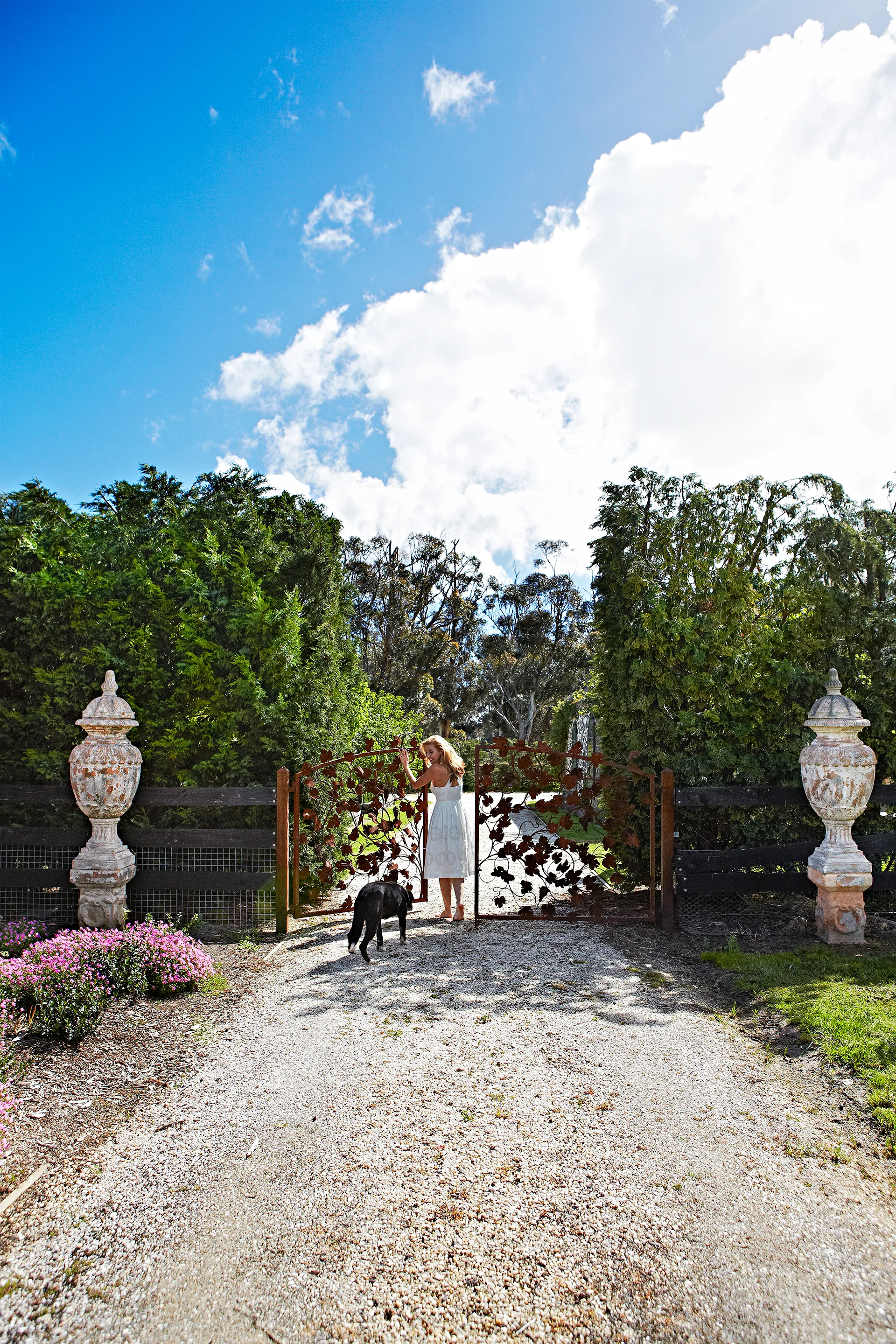 Catriona Rowntree with her dog at the gate of her property in country Victoria.