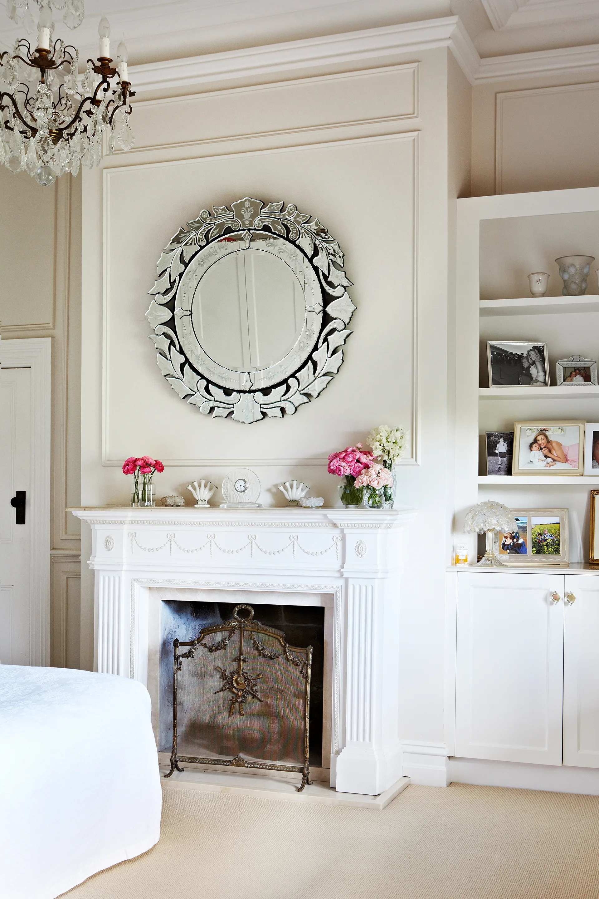 White fireplace with round mirror above it in the home of TV presenter Catriona Rowntree.