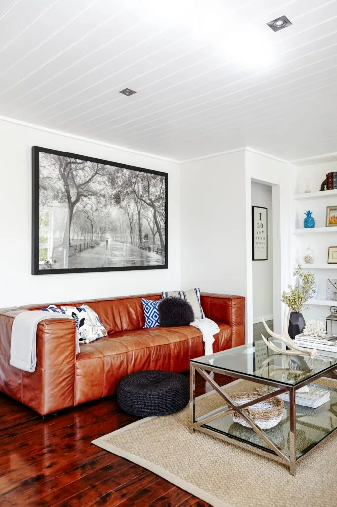 Hamptons meets country living room with brown leather sofa.