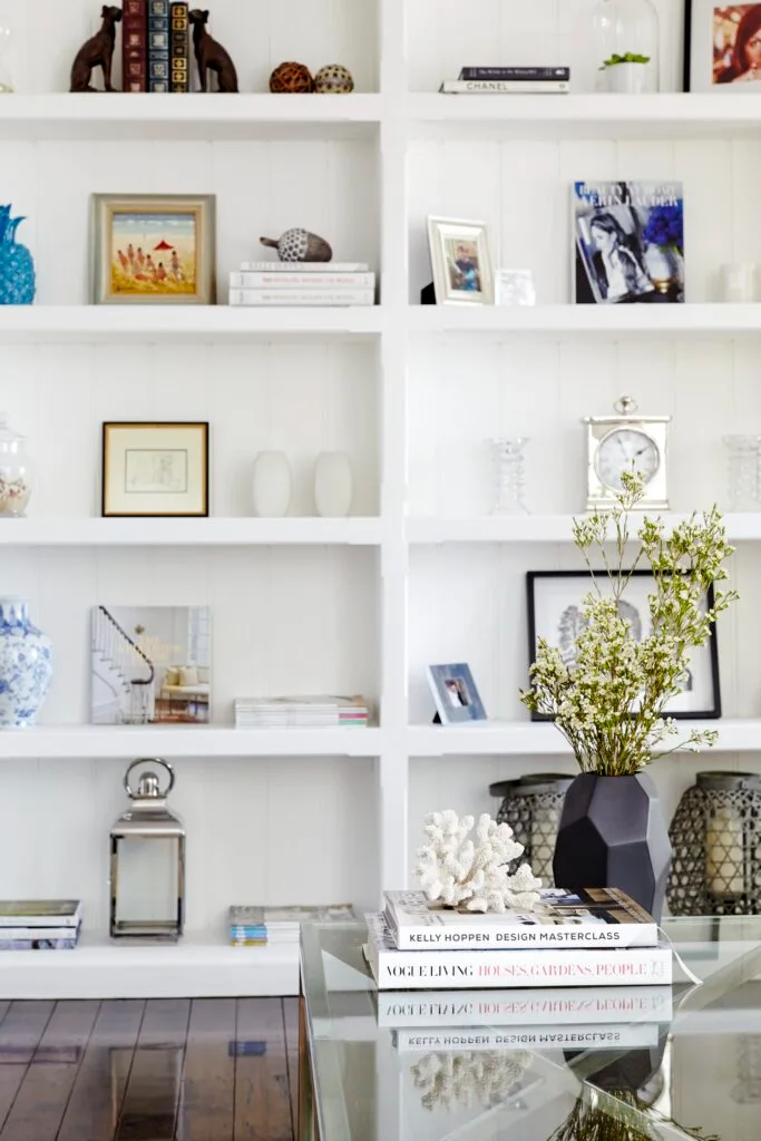 White bookshelf styled with art and objects,