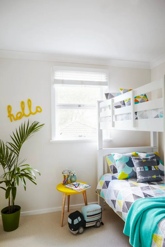 Kids room with bunk beds and blue and yellow colour scheme.