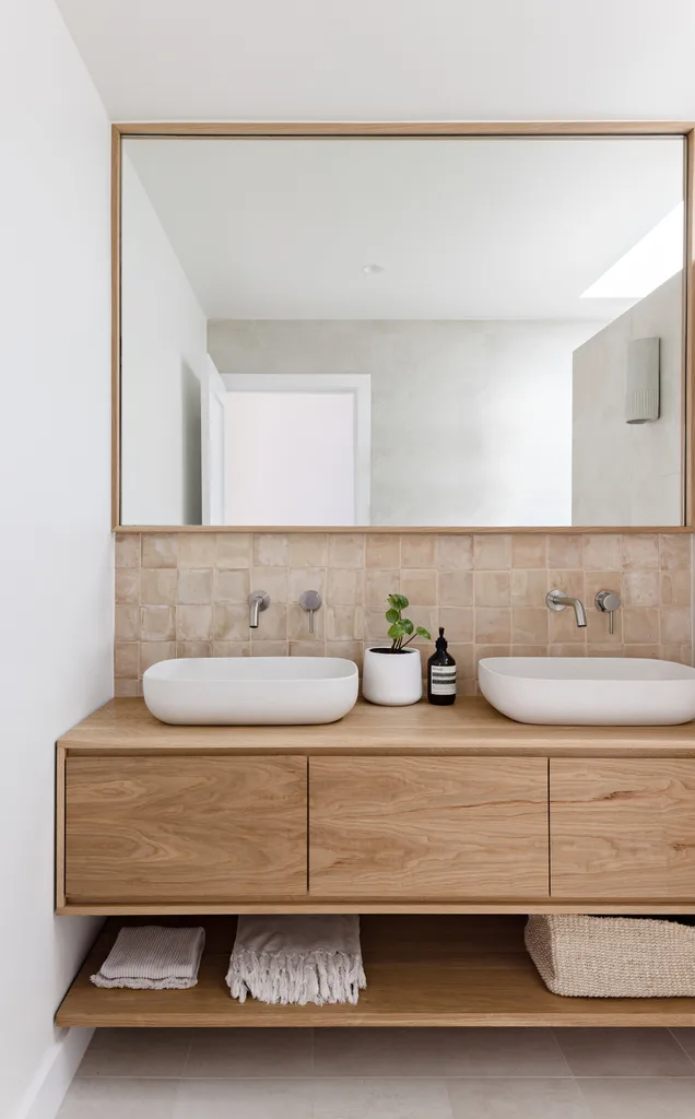 Modern bathroom with floating timber double vanity and large timber framed mirror.