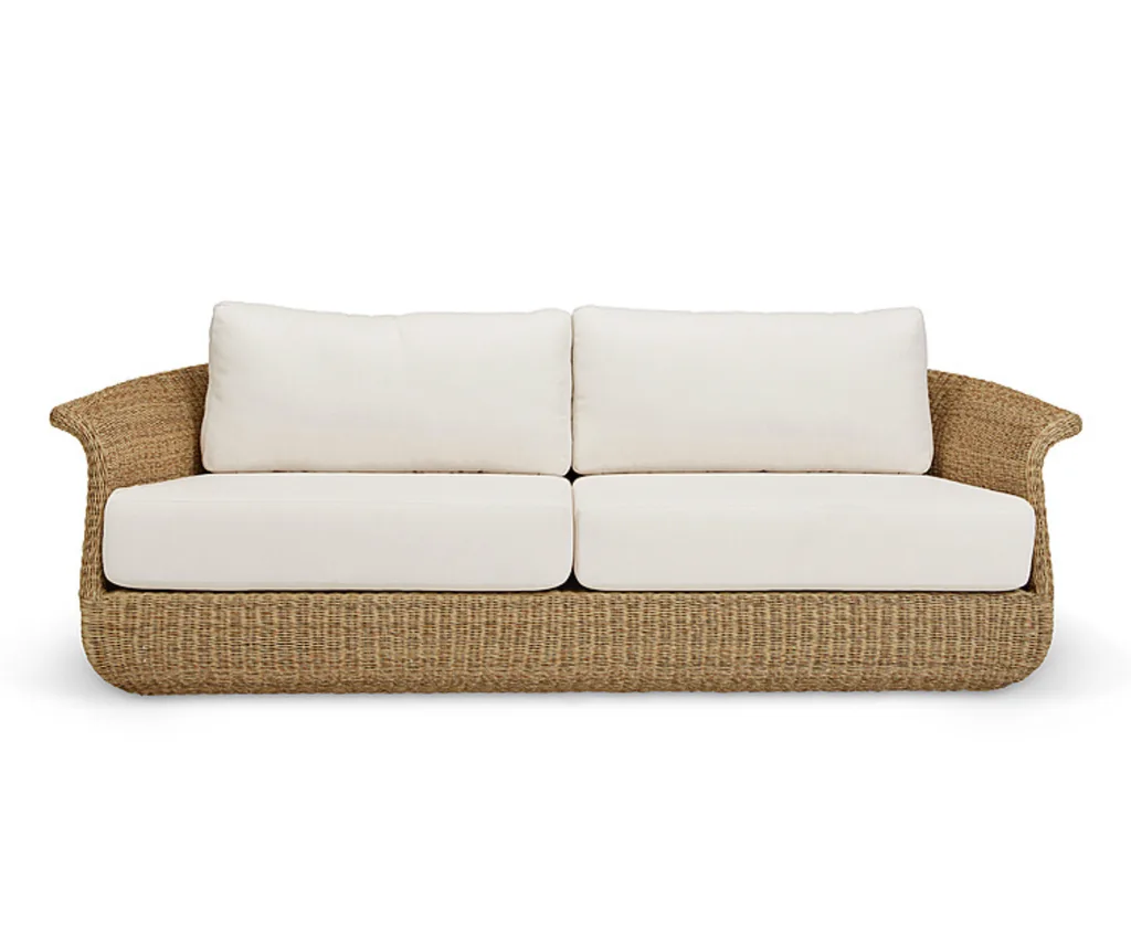 An outdoor sofa with rounded corners and cream cushions