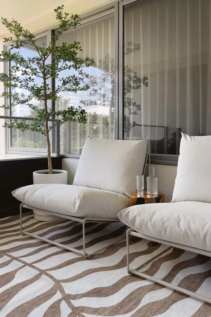 Hanako outdoor rug with outdoor armchairs and side table on a balcony