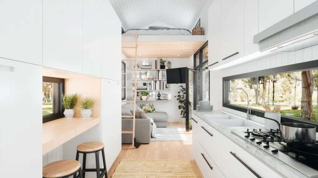 Inside a granny flat with white cabinetry and walls, light timber floors, a loft bed with a ladder and a grey living room set underneath